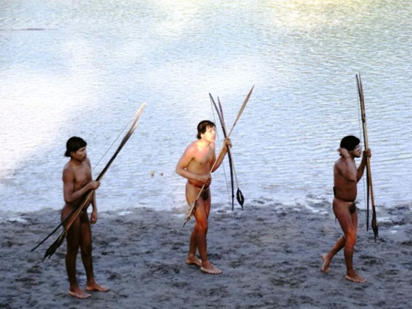 3名最近与外界接触的巴西原始部落成员正手持武器行走，他们中有人在与外界接触中感染了流感病毒。图片来源：巴西印第安人事物管理部门（FUNAI）