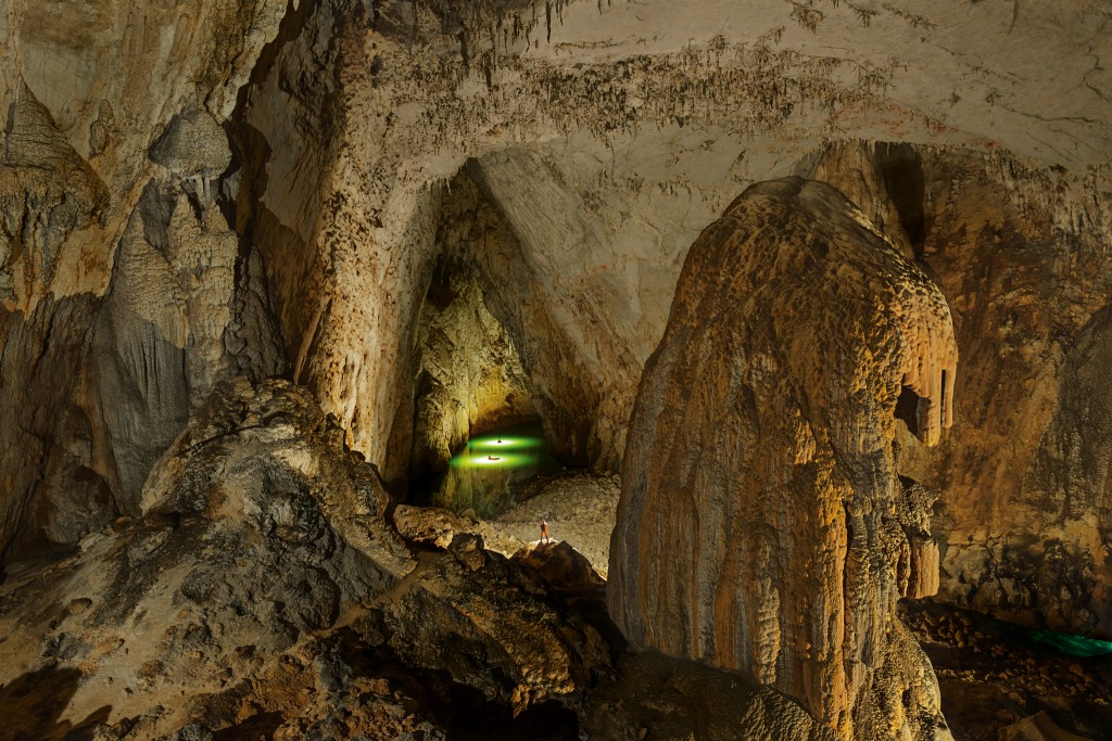 摄影师的灯光照亮苗厅里碧绿的格凸河，苗厅被认为是世界上面积第二大的洞室。