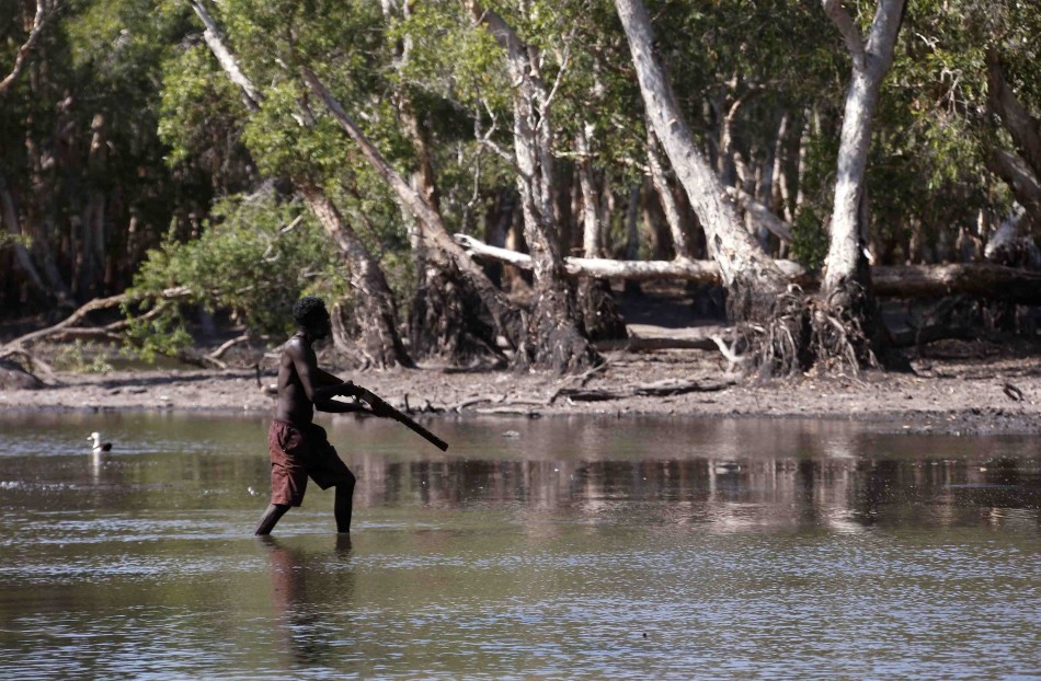 澳大利亚东阿纳姆地原住民保留地，雍古族原住民猎手Roy Gaykamangu拿着猎枪，狩猎一头鳄鱼。