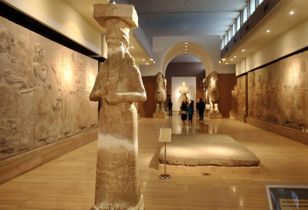 在巴格达的伊拉克国家博物馆里，游客走向亚述时期展区入口两侧的有翼公牛雕像。这个展区内还收藏有古代浮雕，以及用超过300块釉面砖组成的壁画。 Photograph