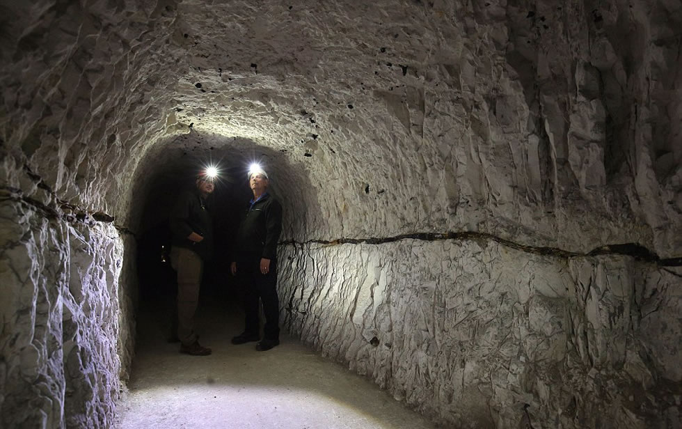 英国国家遗产基金会项目经理乔恩·巴克与志愿者戈登·韦斯戴着头灯，检查多佛的地下通道。