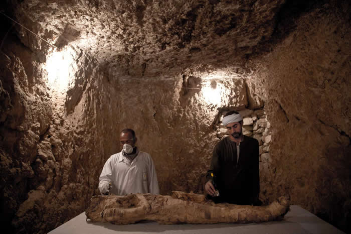 两位工人正在清理一具在埃及路克索找到的古代木乃伊。 PHOTOGRAPH BY NARIMAN EL-MOFTY, AP FOR NATIONAL GEOGRA