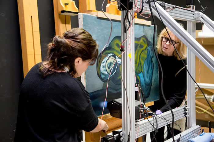西北大学的艾米琳．普叶（左）与安大略美术馆的珊卓．韦布斯特库克架设了X射线萤光仪来扫描毕卡索的画作〈蹲坐的行乞者〉。 PHOTOGRAPH COURTESY A