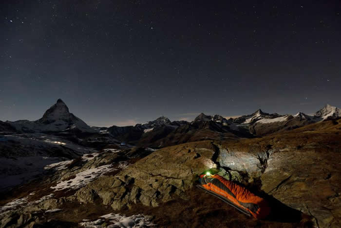 一位意大利探险家以壮丽的马特洪峰（Matterhorn）为背景，安稳地躺进了他的睡袋。 PHOTOGRAPH BY ROBBIE SHONE