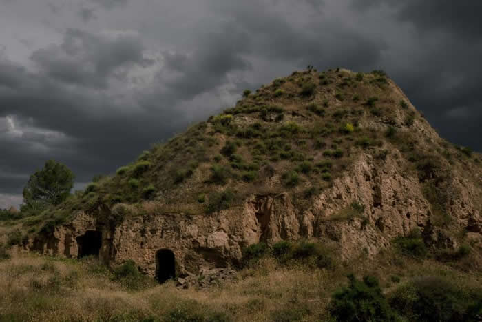 西班牙南部贝纳卢阿村（Benalúa）的一间洞穴屋，入口上方的天色暗了下来。 PHOTOGRAPH BY TAMARA MERINO