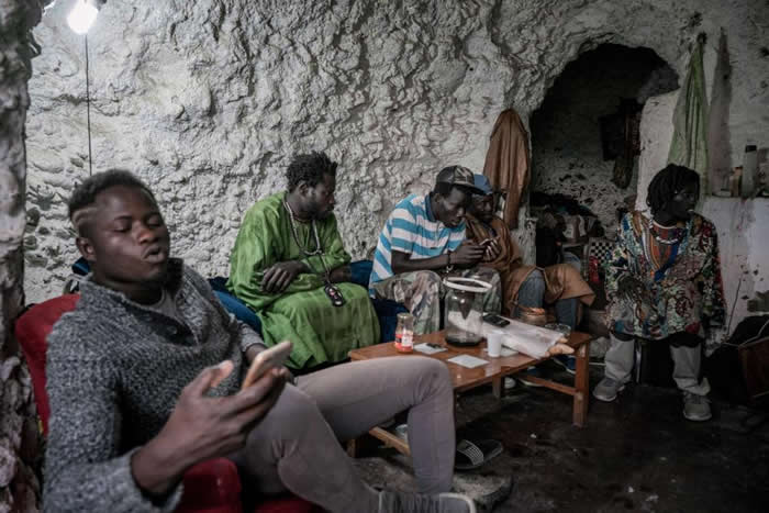 塞内加尔移民坐在山坡高处的一个洞穴内。虽然萨克罗蒙特的洞穴一向被认为是罗姆人的家，但这里的居民实际上来自各地。 HOTOGRAPH BY TAMARA MERI