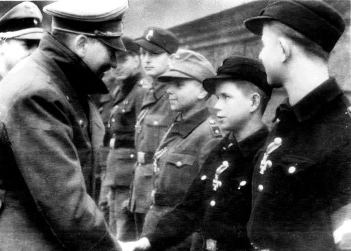 纳粹德国领袖希特拉（左）与少年握手。