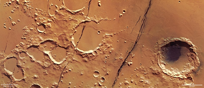 从欧洲太空总署（ESA）火星快车号（Mars Express）轨道卫星于2018年1月拍摄的这张影像中，可以看到布满陨石坑的火星表面有好几道深深的裂缝，这些裂缝