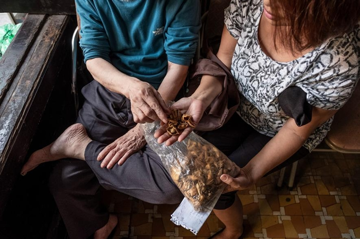 一名越南妇女向传统医学执业者咨询穿山甲鳞片的用法。 PHOTOGRAPH BY BRENT STIRTON, NAT GEO IMAGE COLLECTION
