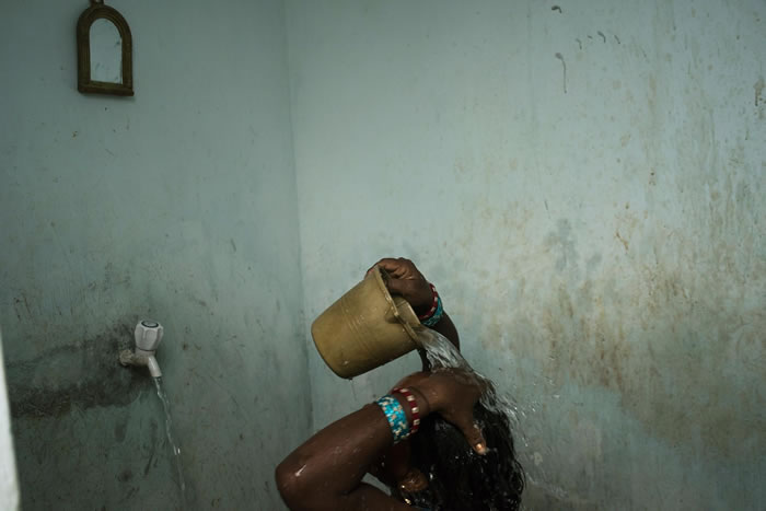在印度东部奥里萨邦的布巴内斯瓦尔市附近，一个女人正在淋浴。 就算是在印度的城市，大部分家庭仍没有自来水;在乡村则是82%的家庭没有自来水。 PHOTOGRAPH