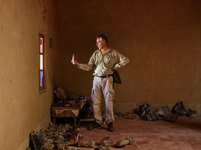 萨米尔. 祖赫里于摩洛哥陶乌兹村民家中检视一根巨大的棘龙牙齿。 活动于这个地区的古生物学家会和当地人建立联系以确保具有科学价值的化石能被送进公共信托机构。 PH