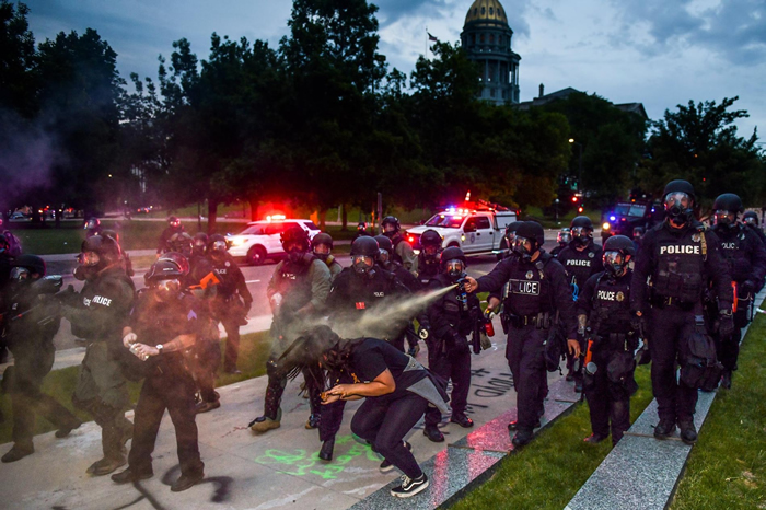 2020年5月30日，群众在科罗拉多州的丹佛连续第三夜抗议乔治. 弗洛伊德之死，警员朝科罗拉多议会大厦旁的一名女性喷洒胡椒喷雾。 PHOTOGRAPH BY M